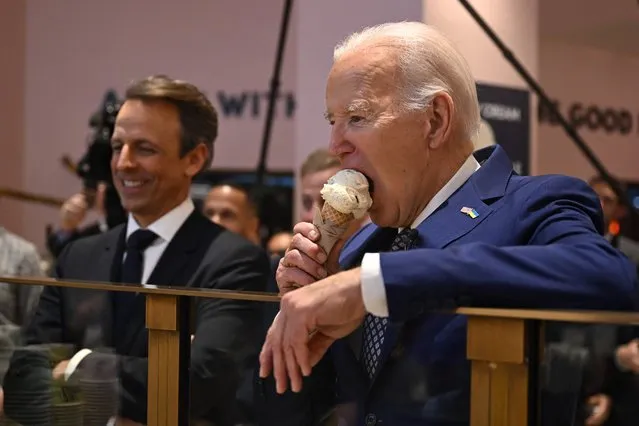 US President Joe Biden (R), flanked by host Seth Meyers (L), eats an ice cream cone at Van Leeuwen Ice Cream after taping an episode of “Late Night with Seth Meyers” in New York City on February 26, 2024. (Photo by Jim Watson/AFP Photo)
