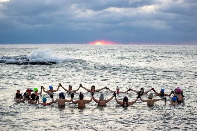 A group consisting mostly of women, who call themselves “The Endorphins”, gather for a sunrise swim in the chilly waters of Lake Ontario during freezing temperatures in Toronto, Ontario, Canada on January 17, 2024. (Photo by Carlos Osorio/Reuters)