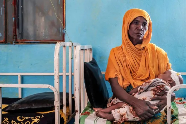 A woman holds a malnourished child at the nutrition unit of the K'elafo Health Center, in the town of K'elafo, Ethiopia, on January 12, 2023. The last five rainy seasons since the end of 2020 have failed, triggering the worst drought in four decades in Ethiopia, Somalia and Kenya. And the next rainy season, from March to May, is also expected to be below average. According to the UN, drought has plunged 12 million people into "acute food insecurity" in Ethiopia alone, where a deadly conflict has also ravaged the north of the country. (Photo by Eduardo Soteras/AFP Photo)