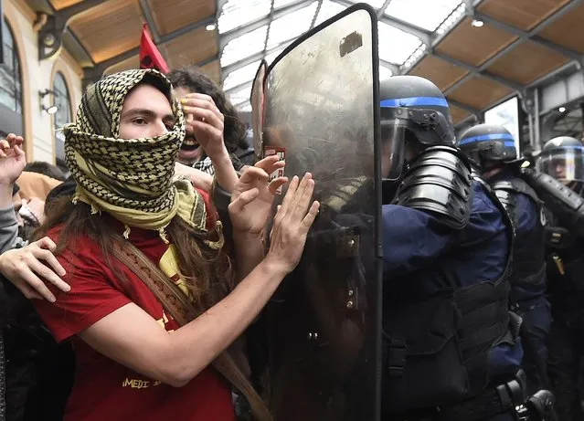 Police officers clash with protesters demonstrating against proposed labour law reforms, on April 12, 2016 at the Saint-Lazare railways station in Paris. French Prime Minister Manuel Valls unveiled measures to help young people find work, aiming to quell weeks of protests against the government's proposed reforms to labour laws. Young people have been at the forefront of mass demonstrations against the reforms over the past month, which the government argues are aimed at making France's rigid labour market more flexible. (Photo by Dominique Faget/AFP Photo)