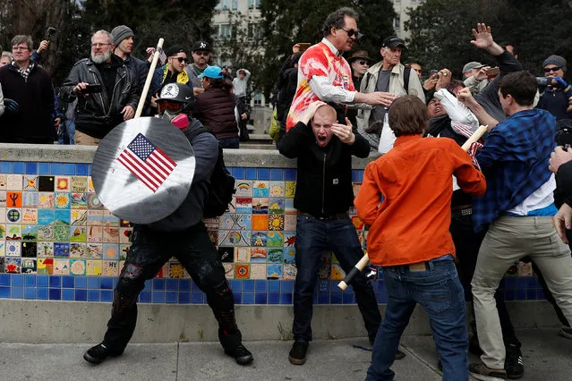 A demonstrator supporting U.S. President Donald Trump (L) holds a shield as a group of men punch a counter demonstrator during a “People 4 Trump” rally in Berkeley, California March 4, 2017. (Photo by Stephen Lam/Reuters)