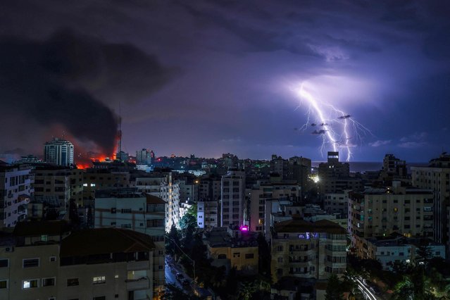 Lightning strikes as smoke billows following an Israeli airstrike in Gaza City on October 9, 2023. The death toll from the unprecedented assault by Palestinian militant group Hamas on its territory rose to 900 in Israel, which has retaliated with a withering barrage of strikes on Gaza, raising the death toll there to 687. (Photo by Mohammed Abed/AFP Photo)