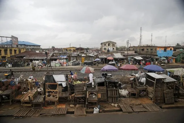 Slum houses are seen built along a train track in the Agege district in Nigeria's commercial capital Lagos April 12, 2016. (Photo by Akintunde Akinleye/Reuters)