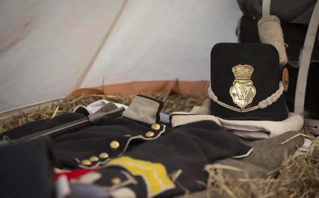In this May 9, 2015, photo, a replica uniform and cap of the Belgian-Dutch 7th Battalion of the Line are laid out on a straw mattress inside a tent at a Napoleonic era living history camp in Elewijt, Belgium. The Belgian-Dutch living history group is coordinating their group for participation in the 200th anniversary of the Battle of Waterloo which will take place in June 2015. (AP Photo/Virginia Mayo)