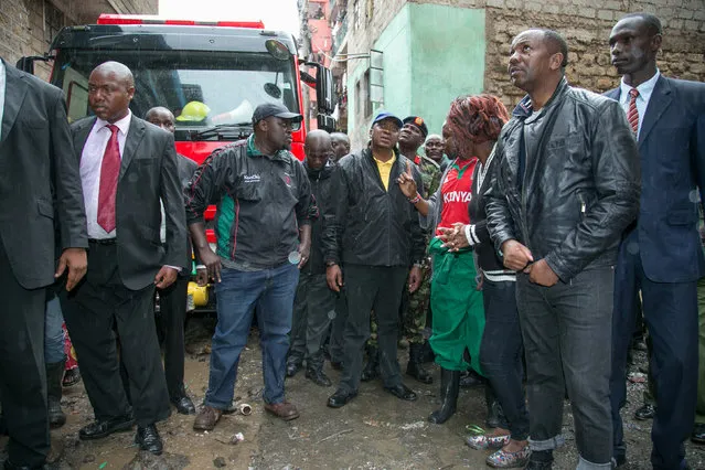 Kenya's President Uhuru Kenyatta (C) visits at the site of rescue operations of residents feared trapped in the rubble of a six-storey building that collapsed after days of heavy rain, in Nairobi, Kenya April 30, 2016. (Photo by Samuel Miringu/Reuters/PPS)