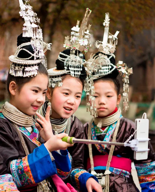 This photo taken on March 19, 2017 shows villagers taking selfies during a traditional celebration for the spring season in the village of Douzhai in Congjiang county, in southwest China' s Guizhou province. (Photo by AFP Photo/Stringer)