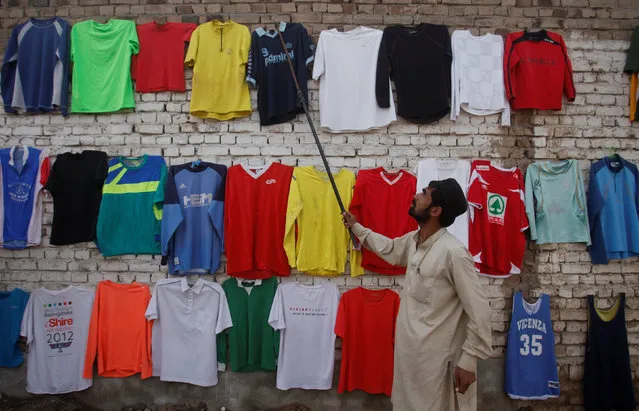 A shirt seller hangs one of his t-shirts on a wall in Charsadda, Pakistan February 27, 2017. (Photo by Fayaz Aziz/Reuters)