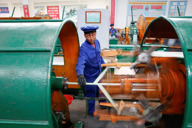 A worker works on a machine during a government organised visit for foreign reporters to the Pyongyang 326 Electric Cable Factory in Pyongyang, North Korea May 6, 2016. (Photo by Damir Sagolj/Reuters)