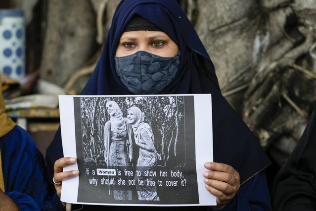 An Indian Muslim woman holds a placard during a protest against banning Muslim girls wearing hijab from attending classes at some schools in the southern Indian state of Karnataka, in Kolkata, India, Thursday, February 10, 2022. (Photo by Bikas Das/AP Photo)