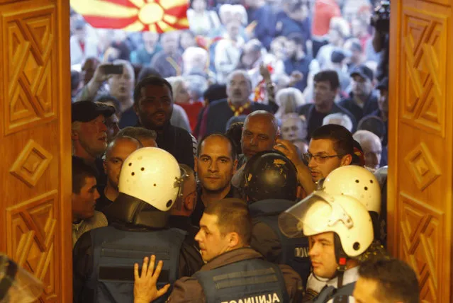 Police try to block protestors as they enter into the parliament building in Skopje, Macedonia, Thursday, April 27, 2017. Scores of protesters have broken through a police cordon and entered Macedonian parliament to protest the election of a new speaker despite a months-long deadlock in talks to form a new government. (Photo by Boris Grdanoski/AP Photo)
