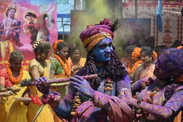 Youths smeared in coloured powder and dressed as Lord Krishna (L) and deity Radha (R) celebrate with others the Holi festival, the Hindu spring festival of colours, in Kolkata on March 17, 2022. (Photo by Dibyangshu Sarkar/AFP Photo)
