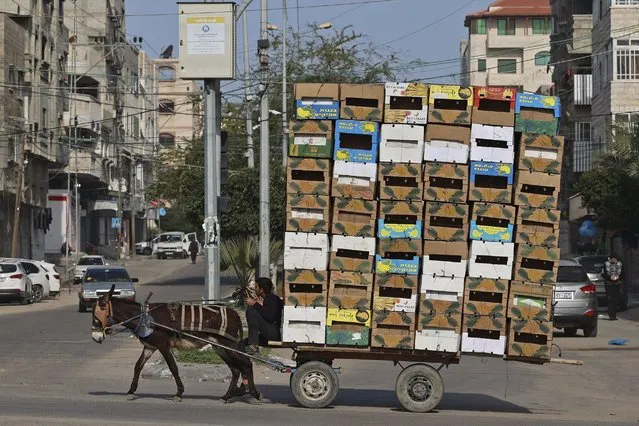 A Palestinian man rides his donkey cart loaded with boxes in Gaza city,on February 17, 2022. (Photo by Mohammed Abed/AFP Photo)