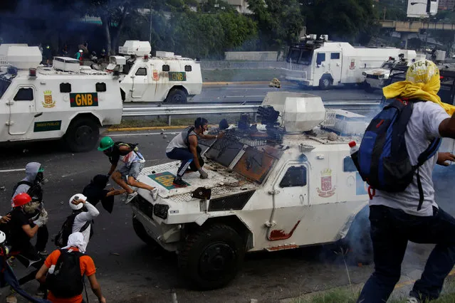 Demonstrators clash with a riot police armored car during a rally against Venezuela's President Nicolas Maduro in Caracas, Venezuela May 1, 2017. (Photo by Carlos Garcia Rawlins/Reuters)