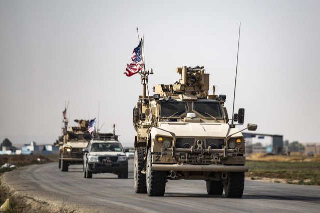 US military vehicleS drive on a road after US forces pulled out of their base in the Northern Syriain town of Tal Tamr on October 20, 2019. US forces withdrew from a key base in northern Syria today, a monitor said, two days before the end of a US-brokered truce to stem a Turkish attack on Kurdish forces in the region. (Photo by Delil Souleiman/AFP Photo)