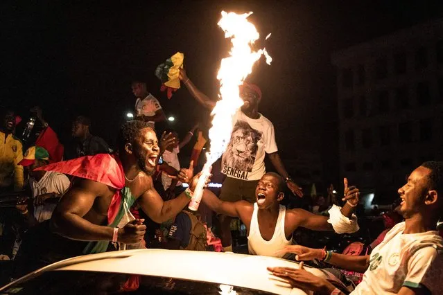 Supporters of Senegal national football team celebrate in Dakar on January 6, 2022, after Senegal won the Africa Cup of Nation (CAN) in the final match against Egypt in Yaounde, Cameroon. (Photo by John Wessels/AFP Photo)