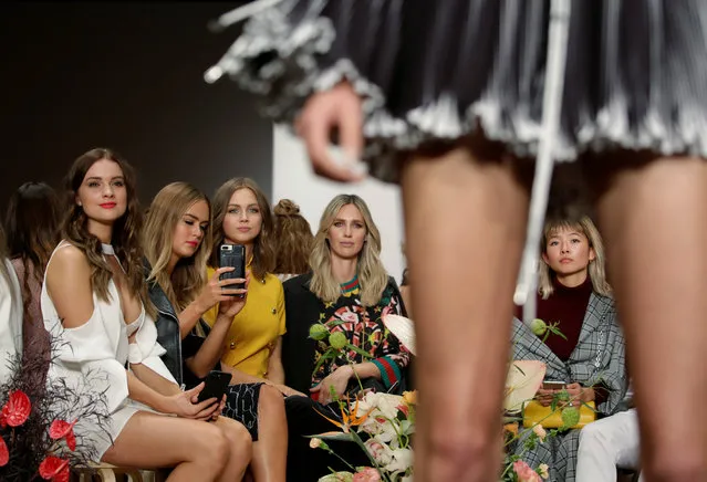 Members of the audience sit in the centre of the catwalk as the watch models for the C/MEO Collective walk by at Fashion Week Australia in Sydney on May 17, 2017. (Photo by Jason Reed/Reuters)