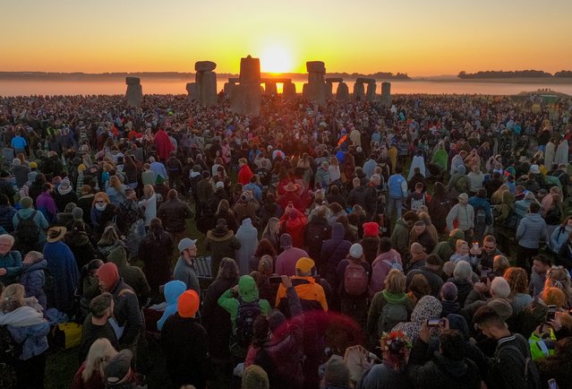 Visitors watch the sunrise at Stonehenge, on June 21, 2024 in Wiltshire, England. On the longest day of the year in the Northern Hemisphere, the sun rises in perfect alignment with the Heel Stone and Altar Stone of Stonehenge's 5000-year-old circle. This alignment shows the ancient builders' understanding of the solar calendar and suggests Stonehenge may have served as a calendar or temple for important dates and events - a tradition that continues to be marked each year. (Photo by Finnbarr Webster/Getty Images)