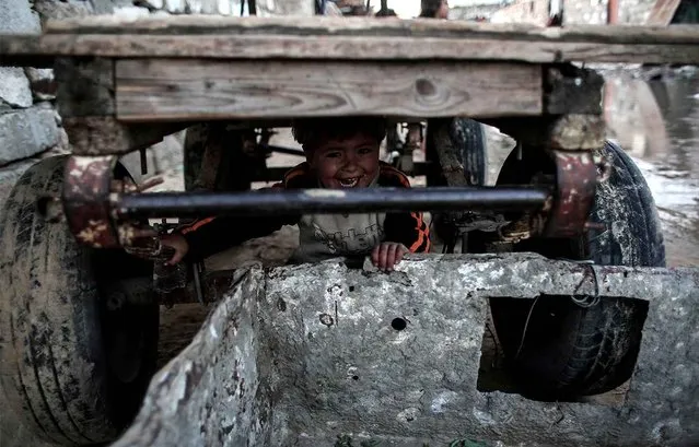 A Palestinian boy plays under a donkey cart outside his house in an impoverished area in the southern Gaza Strip town of Khan Yunis on February 19, 2017. (Photo by Said Khatib/AFP Photo)