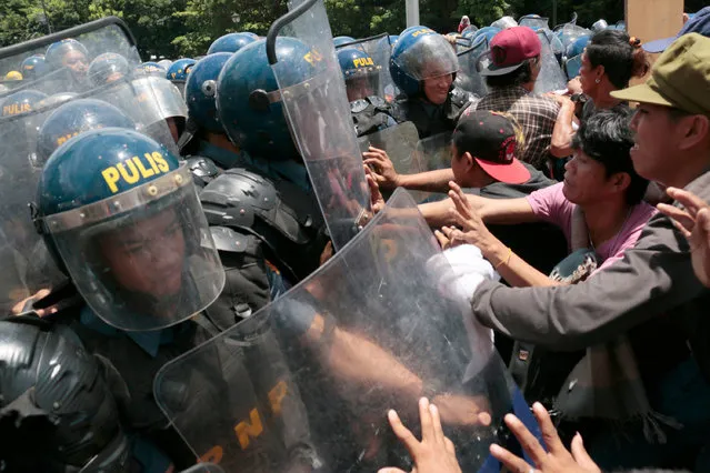 Filipino protesters clash with police near the US Embassy as the country marks its Independence Day in Manila on June 12, 2017. Peace advocates and human rights activists used the holiday attend marches to condemn the government' s policies on issues like the martial law and US military intervention in Mindanao. (Photo by Joseph Agcaoili/AFP Photo)