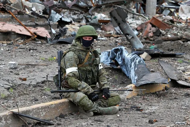 A Russian service member takes a pause while working on demining the territory of Azovstal steel plant during Ukraine-Russia conflict in the southern port city of Mariupol, Ukraine on May 22, 2022. (Photo by Alexander Ermochenko/Reuters)