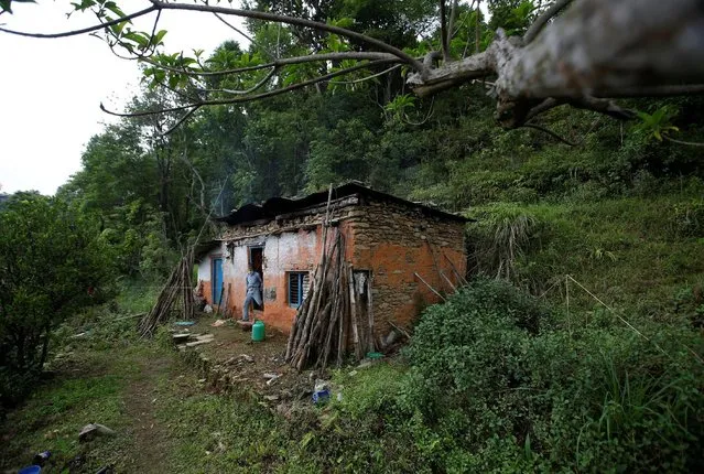Durga Kami, 68, who is currently studying tenth grade at Shree Kala Bhairab Higher Secondary School, leaves his one-room house, where he has lived alone since his wife died, in Syangja, Nepal, June 5, 2016. (Photo by Navesh Chitrakar/Reuters)
