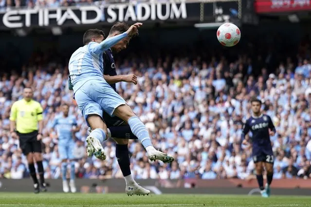 Manchester City's Joao Cancelo, left, fails to stop Aston Villa's Matty Cash from scoring his sides first goal during the English Premier League soccer match between Manchester City and Aston Villa at the Etihad Stadium in Manchester, England, Sunday, May 22, 2022. (Photo by Dave Thompson/AP Photo)