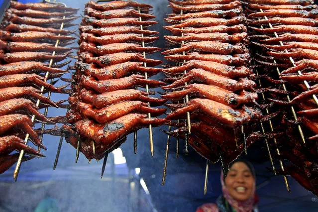 A vendor prepares grilled chicken wings for sale at a Ramadan bazaar in Shah Alam, outside Kuala Lumpur, Malaysia, Saturday, July 5, 2014. Dozens of Ramadan bazaars have sprouted up in the city to sell food for fasting Muslims during this holy month of Ramadan. (Photo by Lai Seng Sin/AP Photo)