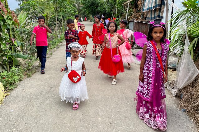 Children walk down a road wearing new dresses on the day of Eid-al-fitr in Munshiganj, Bangladesh, May 3, 2022. (Photo by Mohammad Ponir Hossain/Reuters)