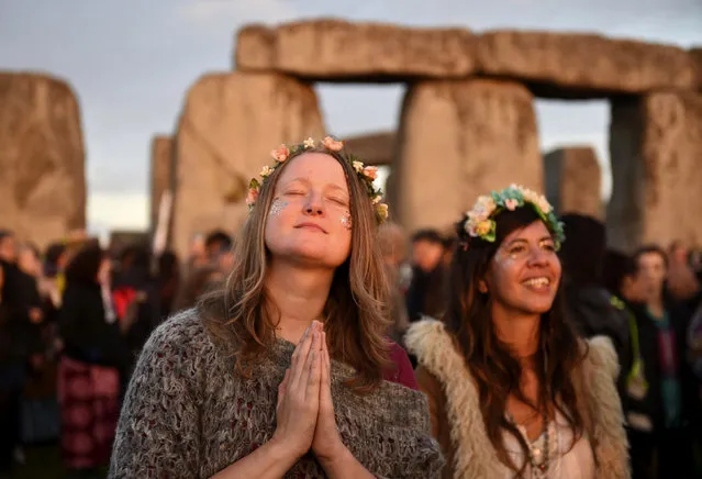 People gather to see the sun rise at the ancient stone circle Stonehenge, during the Summer Solstice, the longest day of the year, in Wiltshire, United Kingdom, Tuesday June 21, 2016. (Photo by Andrew Matthews/PA WIre via AP Photo) 