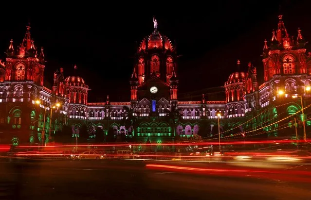Traffic moves in front of the Chhatrapati Shivaji Terminus railway station as it is illuminated with the colours of the Indian flag in lieu of Independence Day in Mumbai, India, August 15, 2015. (Photo by Shailesh Andrade/Reuters)