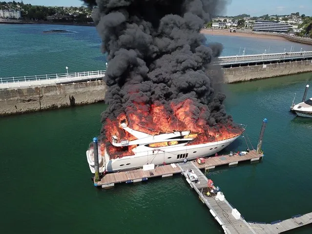A luxury 85ft superyacht reportedly called Rendezvous and thought to be worth £6 million burst into a ball of flames and sank in Torquay marina, England on May 28, 2022. Police confirmed that the yacht, which was carrying an estimated 8,000 litres of diesel, sank shortly before 4pm. They are treating the cause of the fire as “unexplained” and the harbour master and Environment Agency will now work to recover it from under the water. It is unclear who owns the yacht. (Photo by Grace Kedzior-MacDonough/The Times)