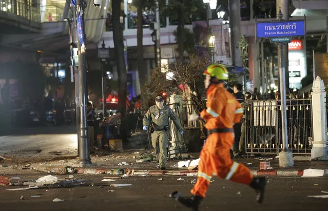 Emergency personnel work at the scene after an explosion in Bangkok, Monday, August 17, 2015. A large explosion rocked a central Bangkok intersection during the evening rush hour, killing a number of people and injuring others, police said. (Photo by Sackchai Lalit/AP Photo)