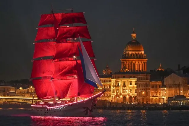 A brig with scarlet sails floats on the Neva River during a rehearsal for the Scarlet Sails festivities marking school graduation in St. Petersburg, Russia, late Wednesday, June 22, 2022. (Photo by Dmitri Lovetsky/AP Photo)