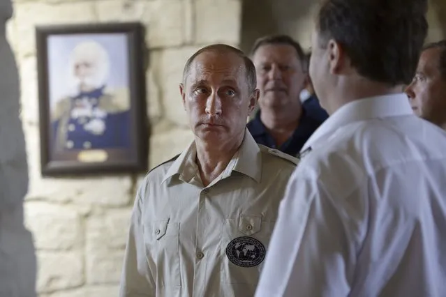 Russian President Vladimir Putin (L), accompanied by Prime Minister Dmitry Medvedev (R) and head of the presidential administration Sergei Ivanov (back), visits the restored historical Konstantinovskaya casemated battery, a fortified cannon position for guarding the bay, in Sevastopol, Crimea, August 18, 2015. (Photo by Alexei Nikolsky/Reuters/RIA Novosti/Kremlin)