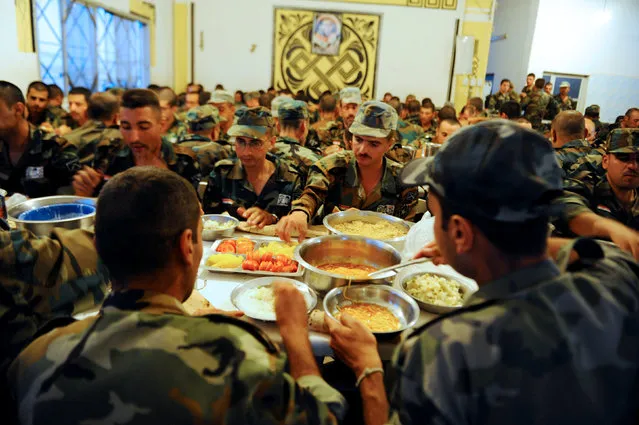 New Syrian army recruits carry eat their Iftar (breaking fast) meals, at a military training camp in Damascus, Syria June 26, 2016. (Photo by Omar Sanadiki/Reuters)