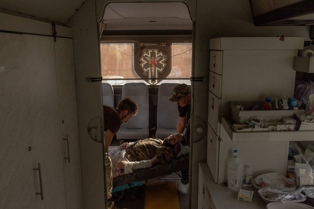 Paramedics of the volunteer medical battalion Hospitallers load a Ukrainian servicemen wounded in fighting in the Donetsk region on a medical evacuation bus driving to a hospital, on October 6, 2024, amid the Russian invasion of Ukraine. The medical evacuation bus called "Austrian” was named after the call sign of the Ukrainian doctor Natalia Frauscher who lived in Austria and died in a traffic accident during her duty on the previous Hospitallers's medical evacuation bus in June 2022. (Photo by Roman Pilipey/AFP Photo)
