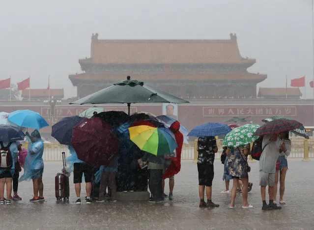 Tourists hold umbrellas as they visit Tiananmen Square during a rainstorm in Beijing, China August 12, 2017. (Photo by Reuters/China Stringer Network)