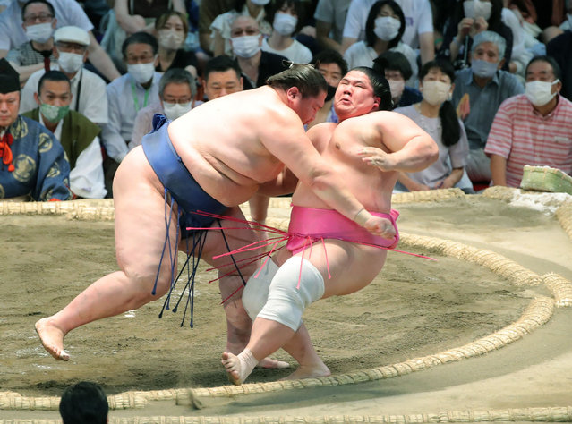 Mongolian-born sumo wrestler Ichinojo (L) pushes out Ura (R) during the final day of the Nagoya Grand Sumo Tournament in Nagoya, Aichi prefecture on July 24, 2022. (Photo by JIJI Press/AFP Photo)