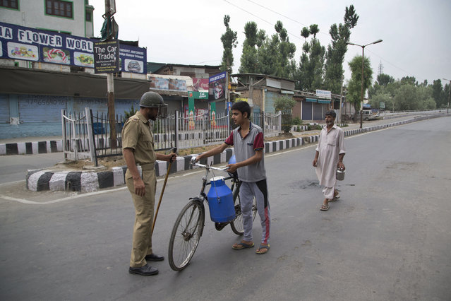 A policeman checks a civilian at a temporary check post during a curfew in Srinagar, Indian controlled Kashmir, Friday, July 15, 2016. (Photo by Dar Yasin/AP Photo)