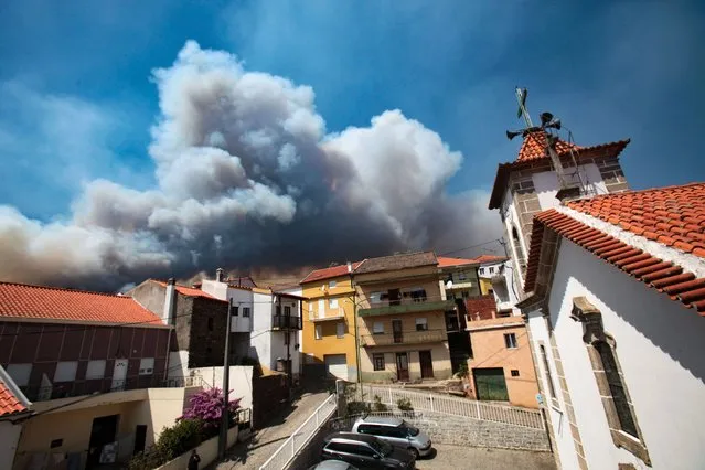 Smoke clouds rise in the village of Verdelhos during a forest fire in the Beijames glacial valley, Covilha, Castelo Branco, Portugal, 09 August 2022. 580 operational, 205 vehicles and 13 airplane are fighting the forest fire. (Photo by Miguel Pereira da Silva/EPA/EFE)