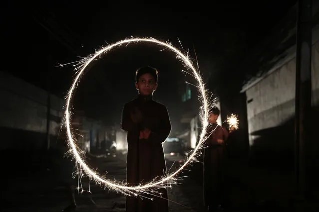 A Yemeni boy plays with fireworks as he celebrates for the upcoming Eid al-Fitr festival, in Sanaa, Yemen, Tuesday, July 5, 2016. (Photo by Hani Mohammed/AP Photo)
