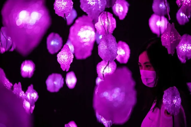 A woman visits “Pixel Forest” by Swiss artist Pipilotti Rist, an art installation of 3000 hand-sculpted LED lights suspended from the ceiling at Tai Kwun in Hong Kong on August 18, 2022. (Photo by Isaac Lawrence/AFP Photo)