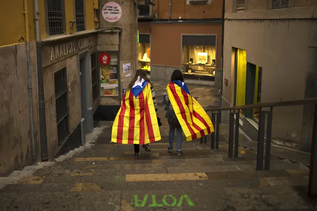 Women with “esteladas”, or Catalonia independence flag, walk along the old quarter in Girona, Spain, Monday, October 2, 2017. Catalonia's government will hold a closed-door Cabinet meeting Monday to discuss the next steps in its plan to declare independence from Spain following a disputed referendum marred by violence. Regional officials say the vote, which Spain insists was illegal and invalid, shows that a majority favor secession. (Photo by Francisco Seco/AP Photo)