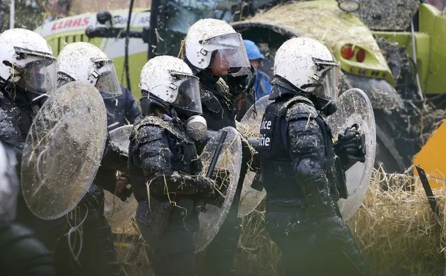 Belgian riot police officers are covered by hay and eggs thrown by demonstrators as farmers and dairy farmers from all over Europe take part in a demonstration outside an European Union farm ministers emergency meeting at the EU Council headquarters in Brussels, Belgium, September 7, 2015. (Photo by Jacky Naegelen/Reuters)