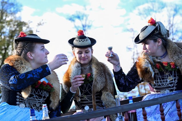 Participants from the farming community, dressed in traditional Bavarian clothing, drink schnapps in a wooden carriage on the way to the chapel on the Kalvarienberg during the Leonhardi Ritt procession, to pray to St Leonhard, the patron saint of animals, in Bad Toelz, Germany on November 6, 2023. (Photo by Angelika Warmuth/Reuters)