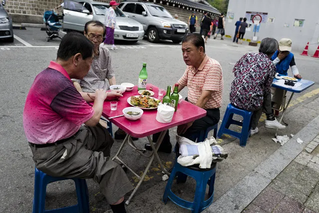 People have chats drinking soju (Korean gin) and makgeolli (Korean rice wine) at open tables by restaurants on a street at Jongno-gu on August 1, 2015 in Seoul, South Korea. (Photo by Shin Woong-jae/The Washington Post)