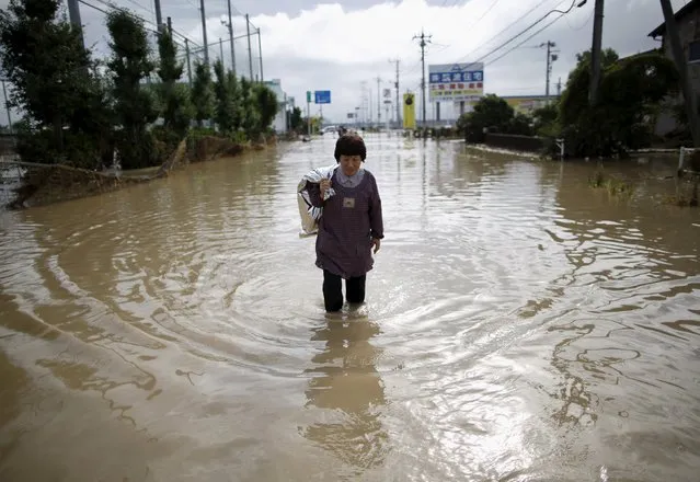A local resident wades through a residential area flooded by the Kinugawa river, caused by typhoon Etau, in Joso, Ibaraki prefecture, Japan, September 11, 2015. (Photo by Issei Kato/Reuters)