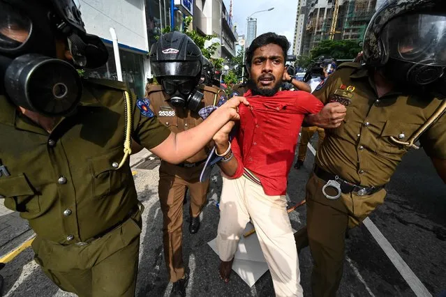 Police detains a Sri Lankan university student during a demonstration in Colombo on August 18, 2022. Sri Lanka police fired tear gas and water cannon on a small protest on August 18 to break up the first demonstration since the crisis-hit island nation lifted a state of emergency. (Photo by Ishara S. Kodikara/AFP Photo)