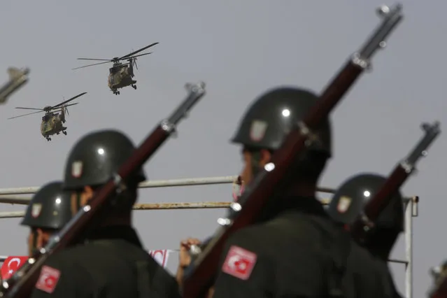 Soldiers march as Turkish air force helicopters fly over a military parade in the Turkish occupied area of the divided capital Nicosia, Cyprus, Wednesday, November 15 , 2017. November 15 marks the 34rd anniversary of the unilateral declaration of independence by the occupation regime, recognized only by Turkey. (Photo by Petros Karadjias/AP Photo)