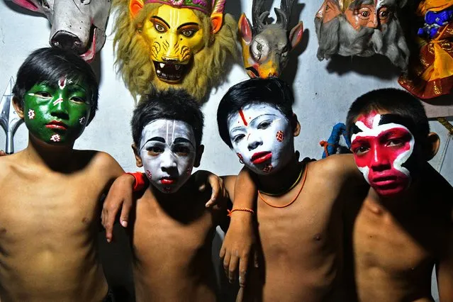 Boys with their painted faces pose before performing in a play during the Indra Jatra festival at Basantapur Durbar Square in Kathmandu on September 12, 2022. (Photo by Prakash Mathema/AFP Photo)